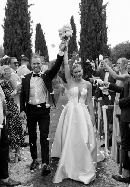 Real Bride und Bräutigam jubeln im Konfettiregen, Schwarzweiß – White Silhouette München