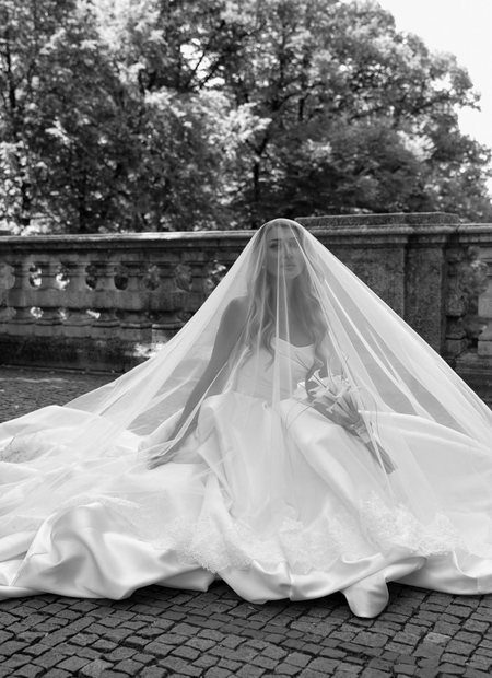 Real Bride mit volumin&ouml;ser T&uuml;llschleppe im Gegenlicht, Schwarz-Wei&szlig;-Aufnahme im Garten